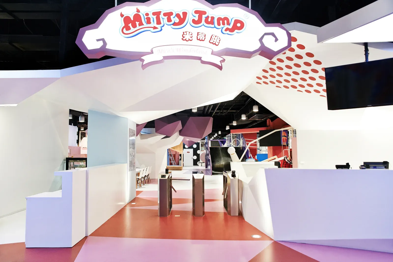 Entrance under the folded roof, with the Mitty Jump sign and reception counters