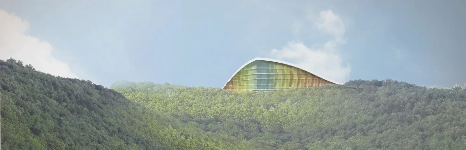 The building seen from a distance, its roof rising above the wooded hills