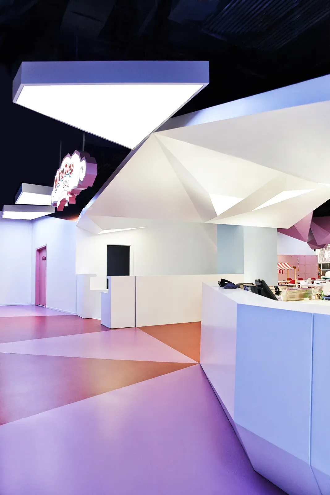 Reception counter under faceted ceiling planes
