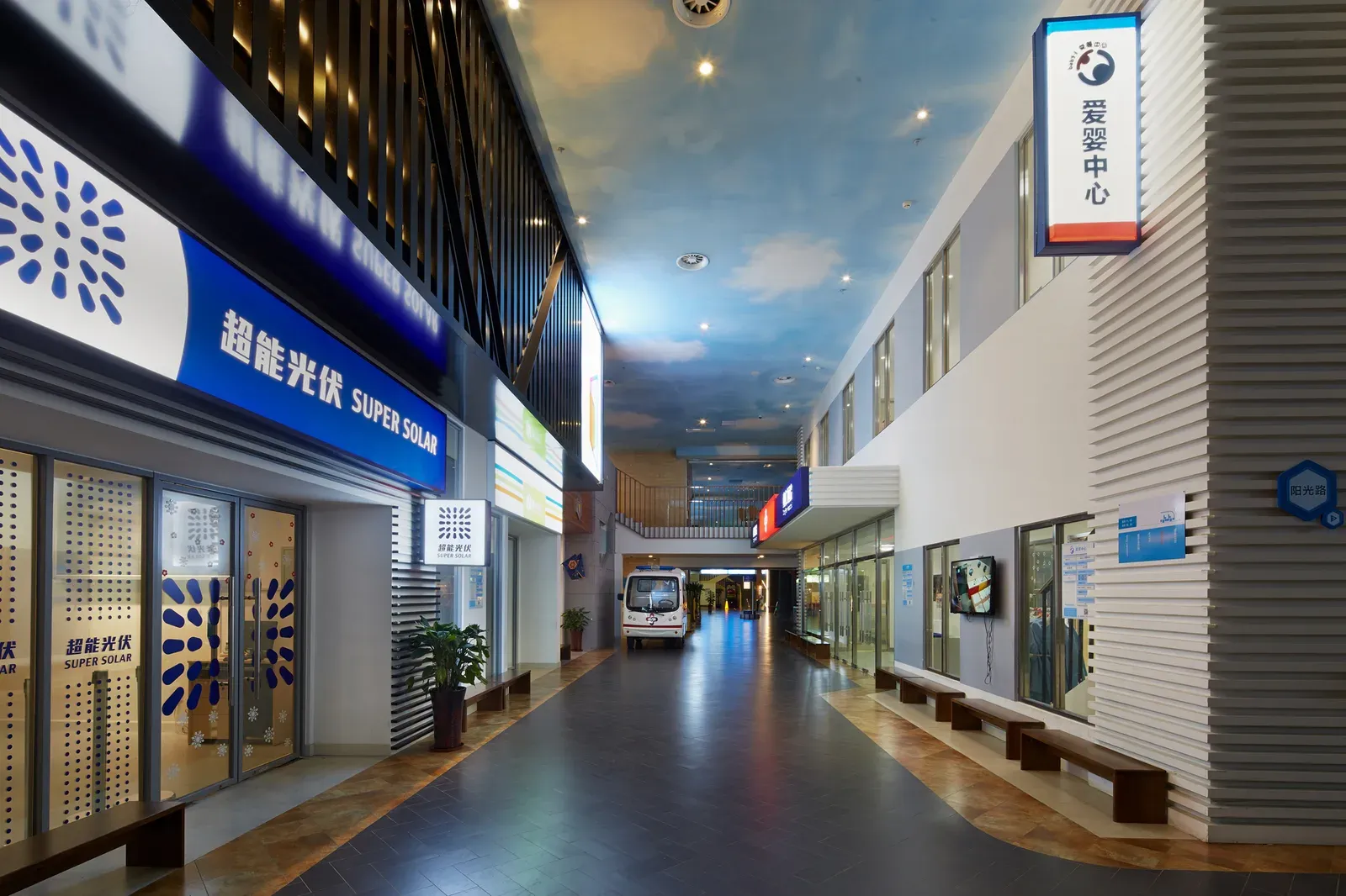 Interior street of shopfronts under the painted-sky ceiling