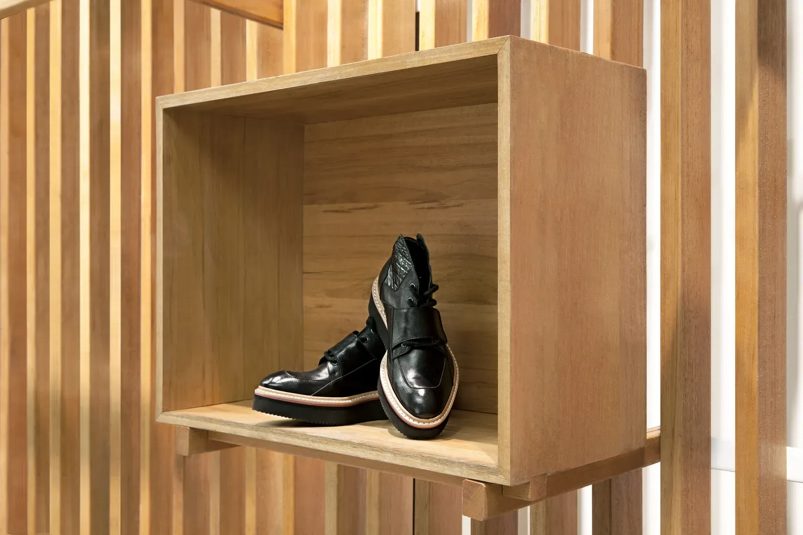 Timber display box holding a pair of shoes